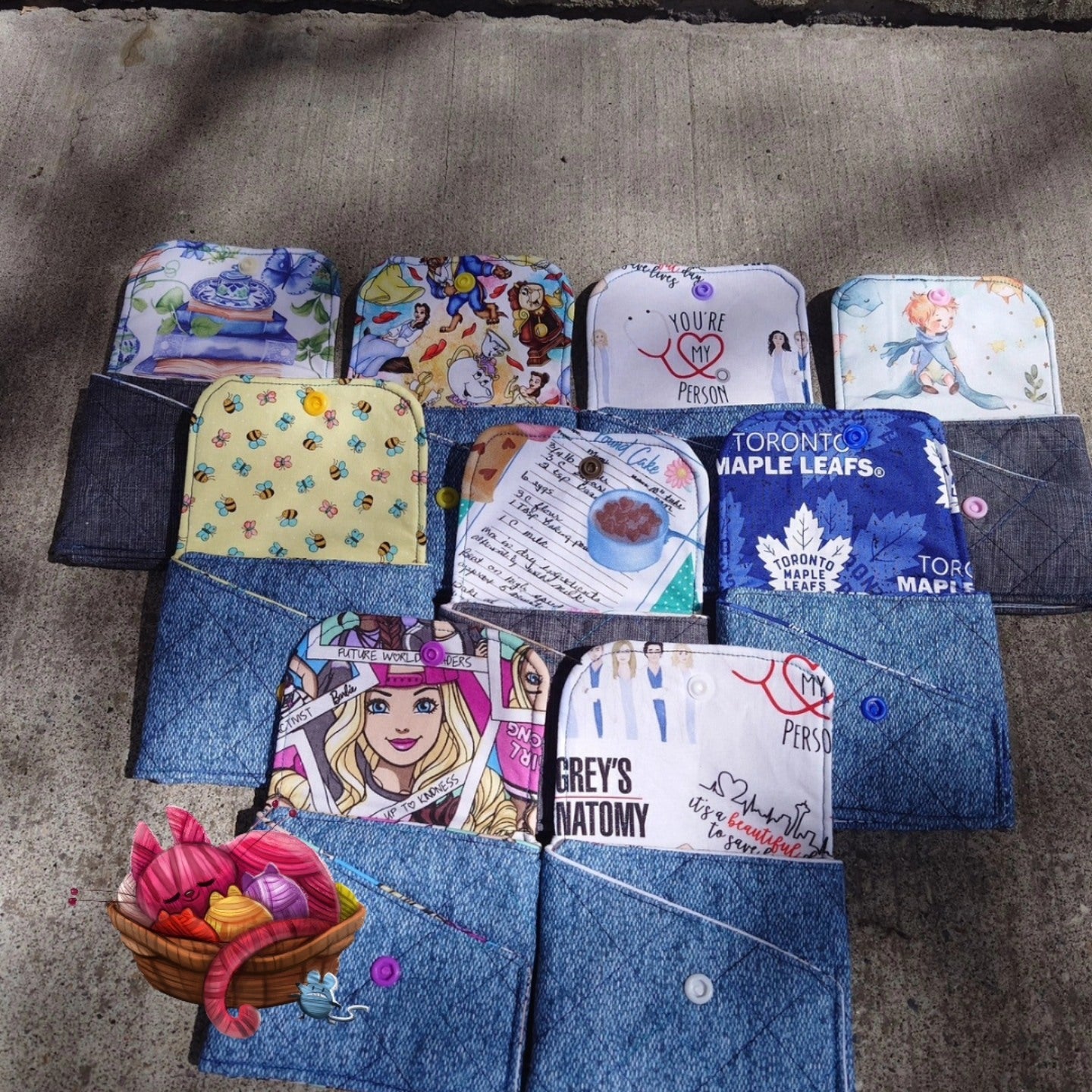 Collection of various denim pouches with different designs on a concrete surface