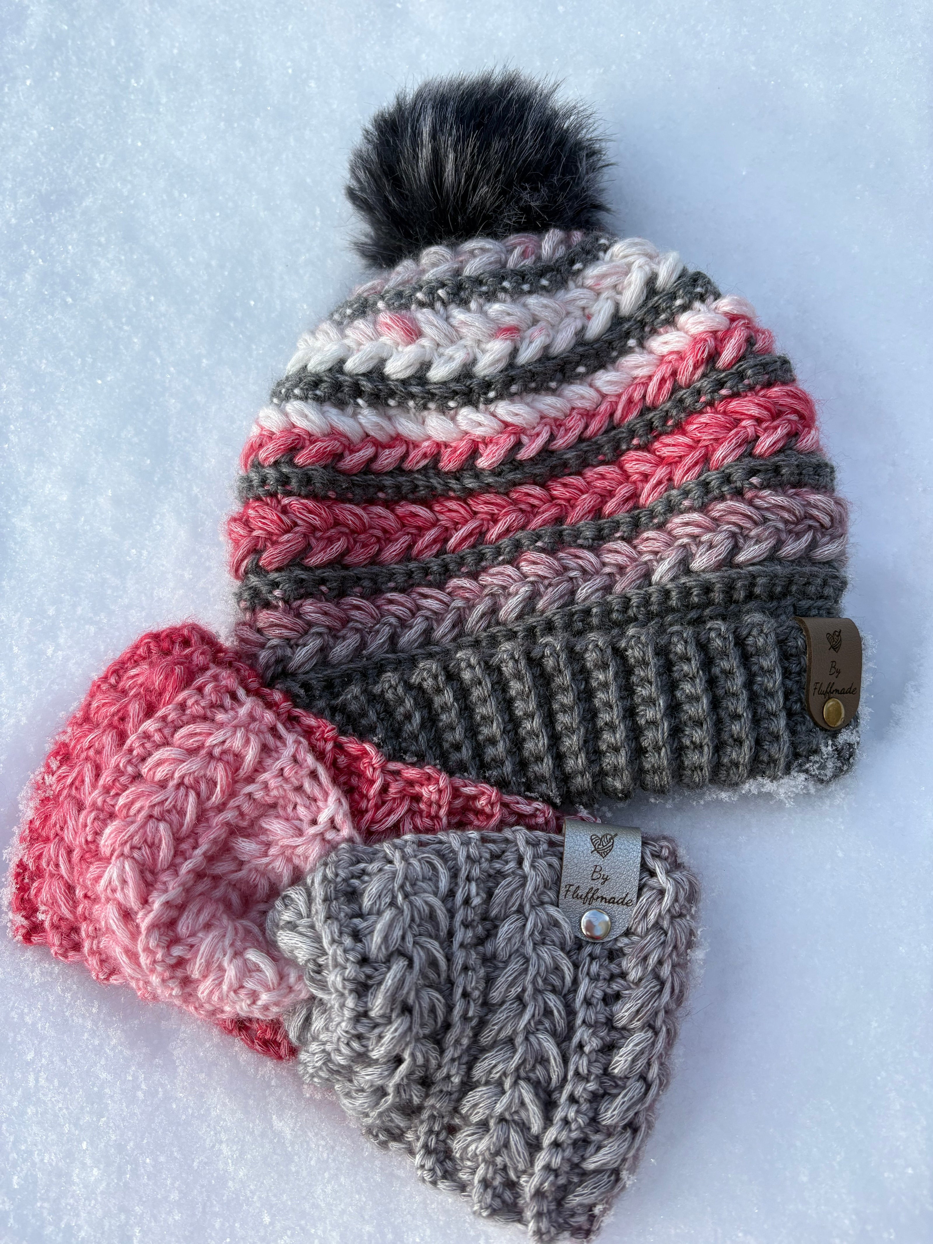 One crochet hats with pom-pom and a headband on a snowy background