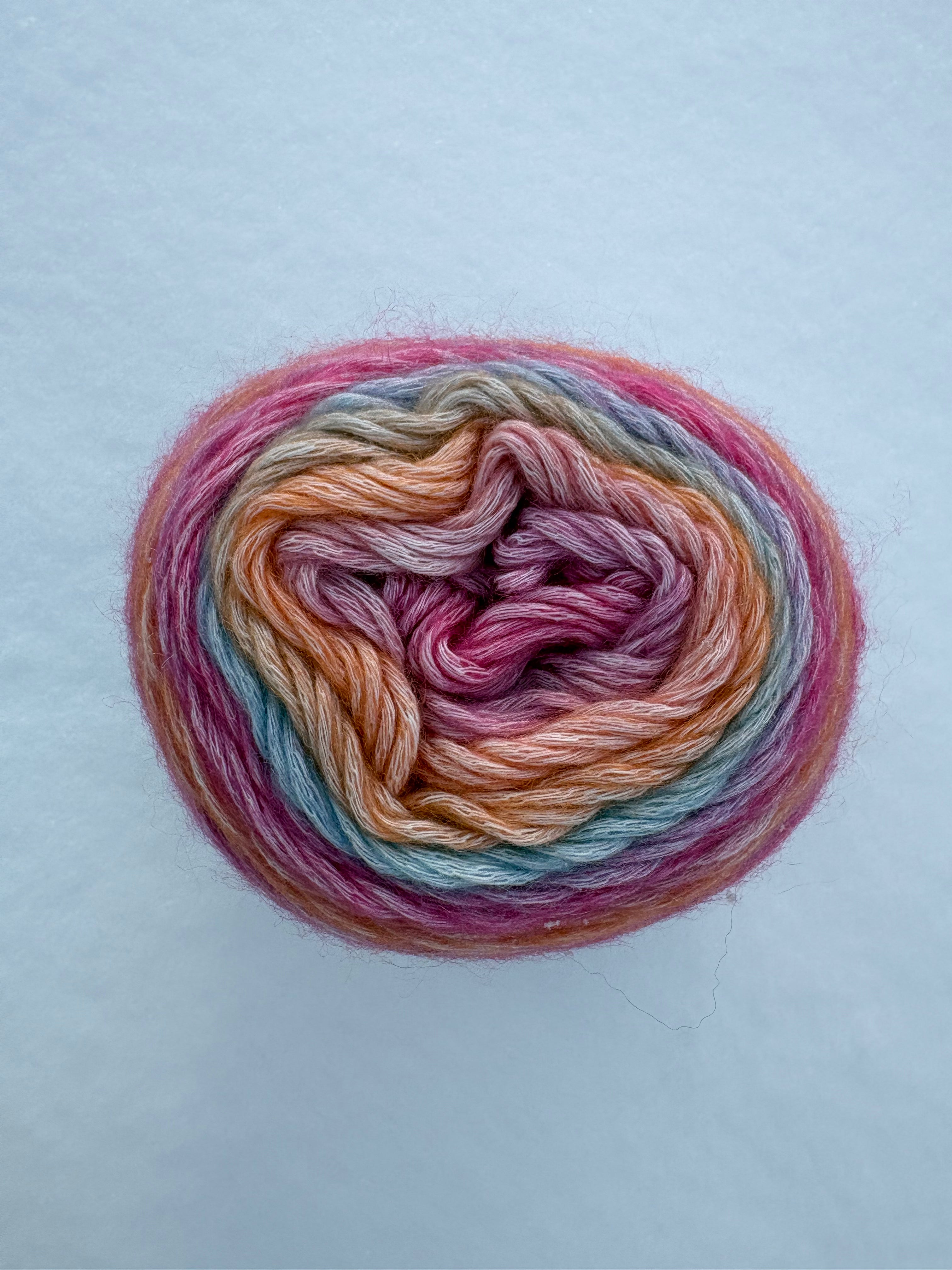 Multicolored skein of yarn on a light blue background