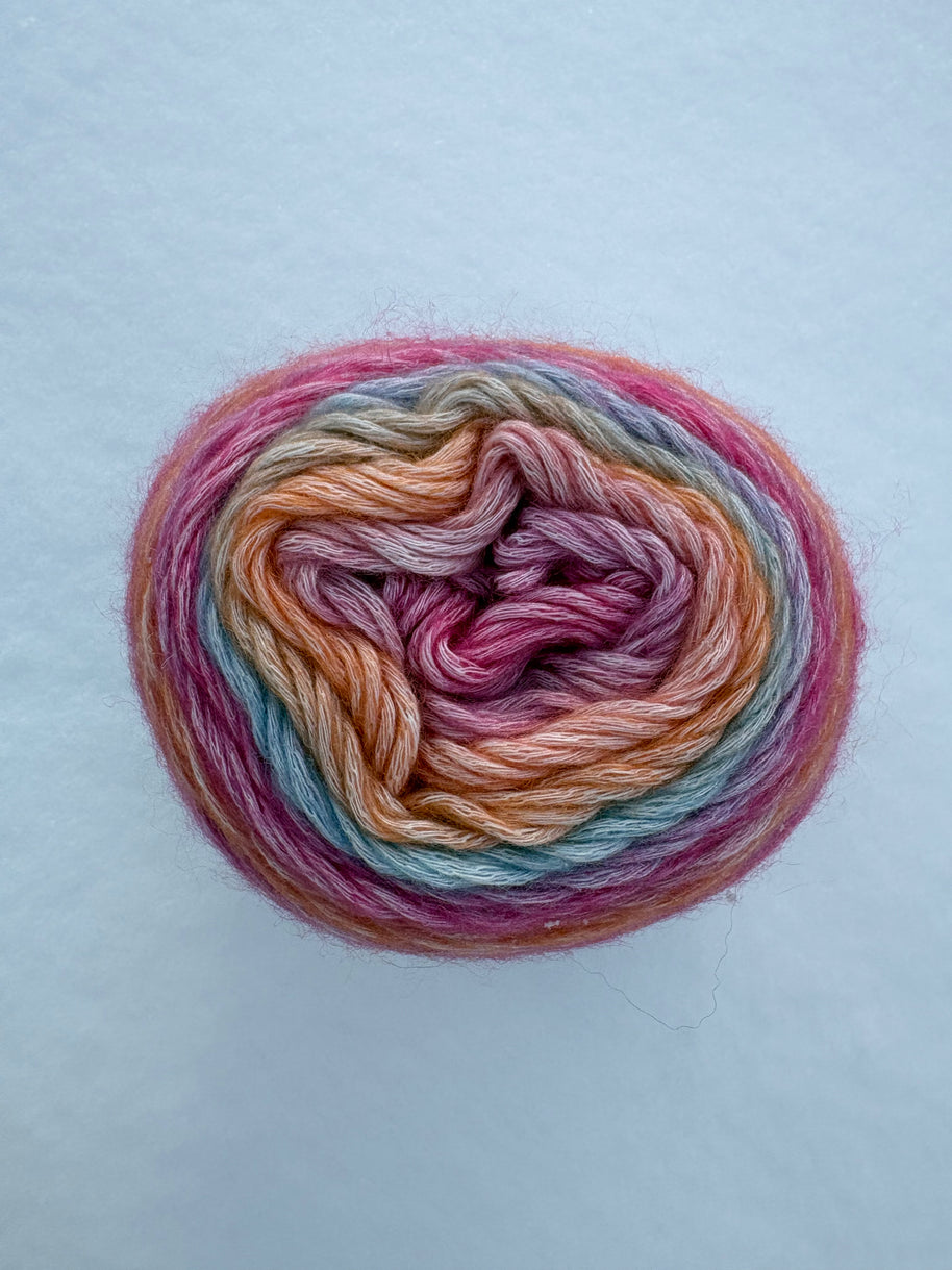Multicolored skein of yarn on a light blue background