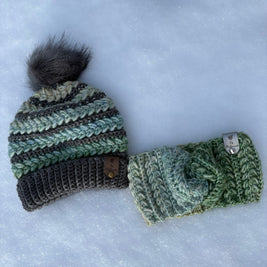 One crochet beanie with pom-pom and a headband on a snowy background in Pistachio Parfait.