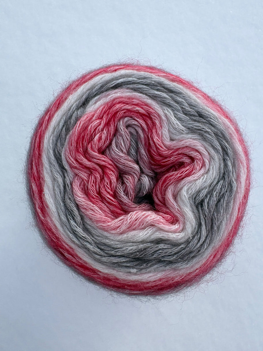 Spool of multicolored yarn on a light gray background