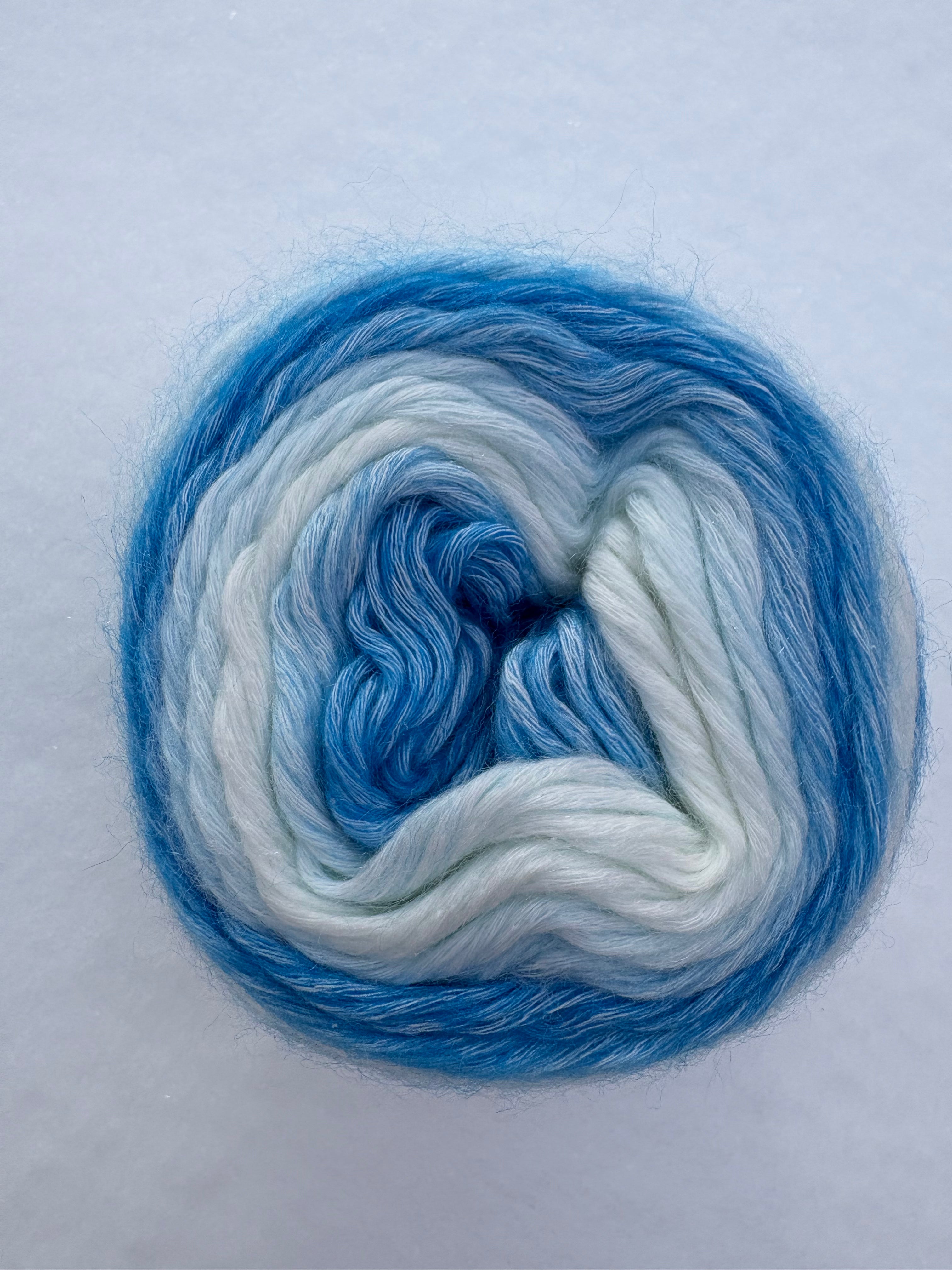 Blue and white yarn skein on a light gray background