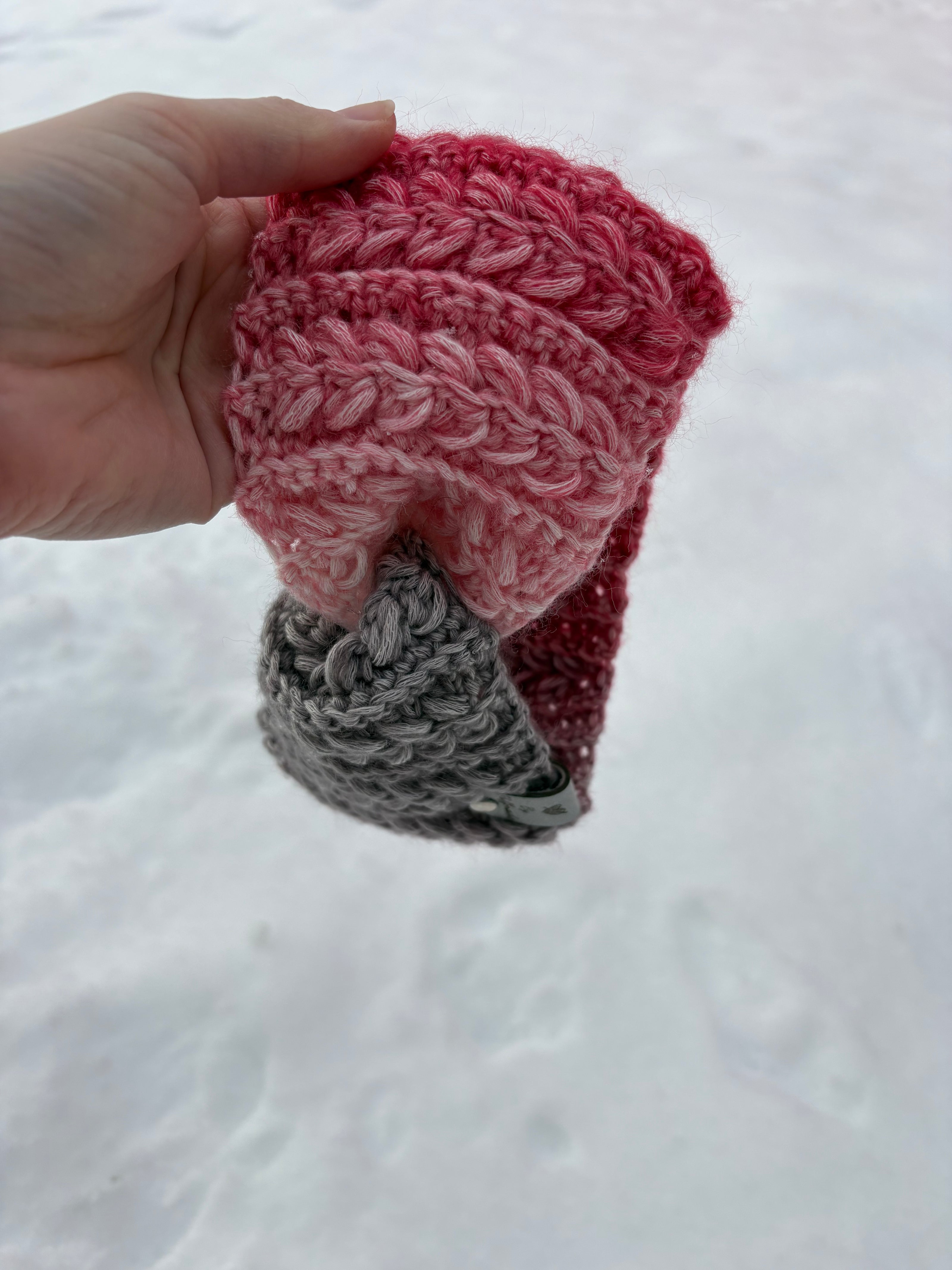 Pink and gray gradient crochet ear warmer with braided texture on snow – Canadian handmade winter accessory.