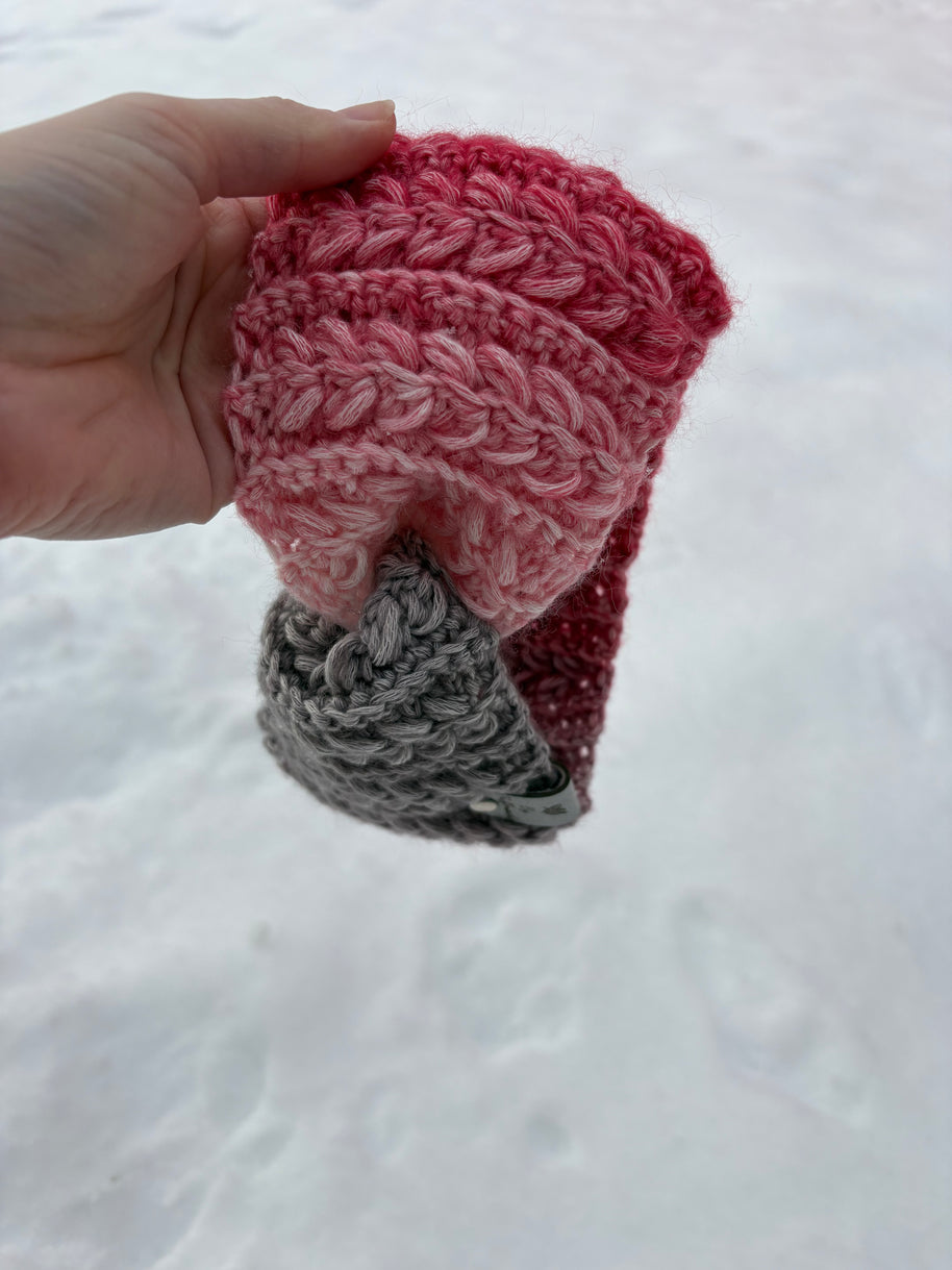 Pink and gray gradient crochet ear warmer with braided texture on snow – Canadian handmade winter accessory.
