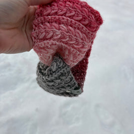 Pink and gray gradient crochet ear warmer with braided texture on snow – Canadian handmade winter accessory.