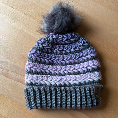 Purple and grey crochet toque with grey faux fur pom and braided texture – handcrafted in Canada.