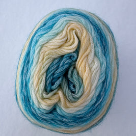 Wool yarn skein with blue and beige colors on a white background