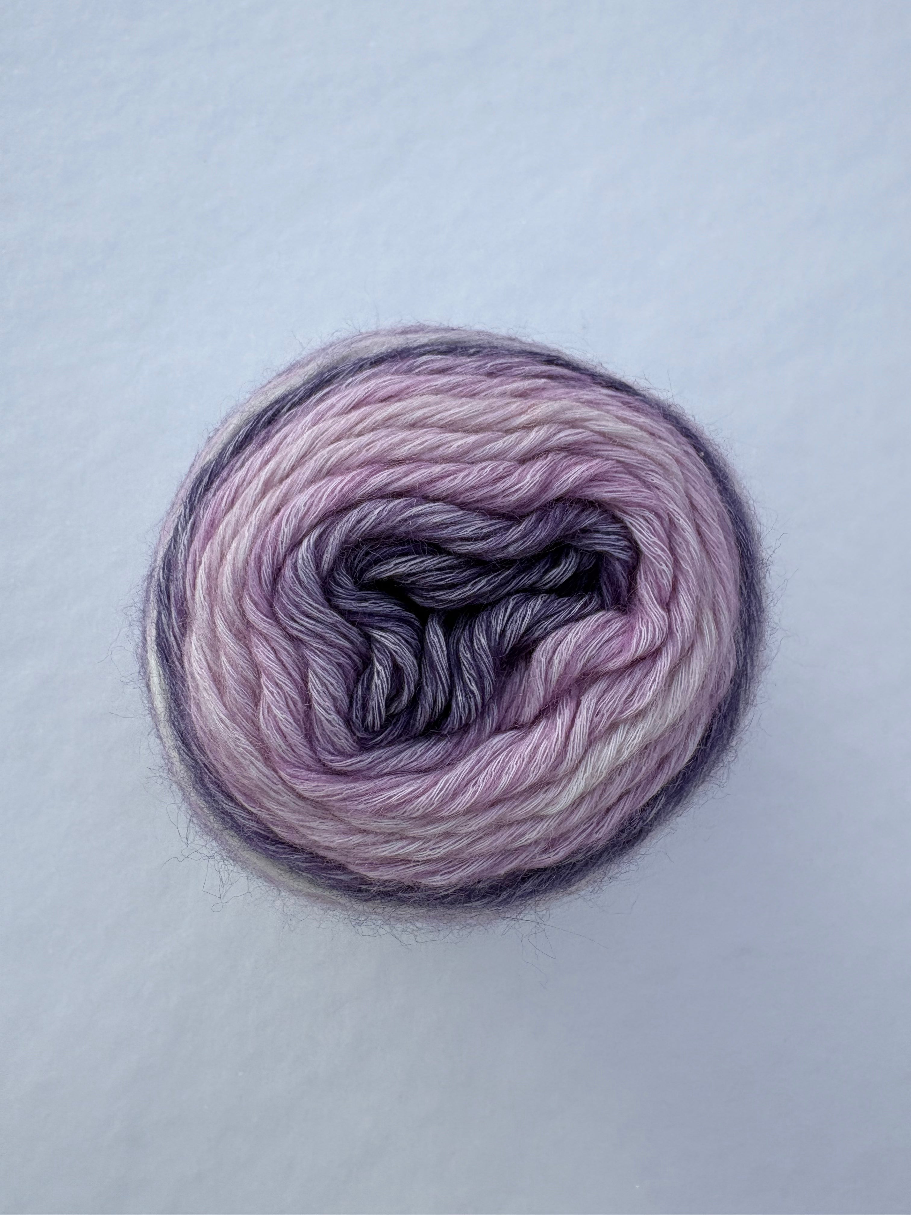 Ball of pink and purple yarn on a light gray background